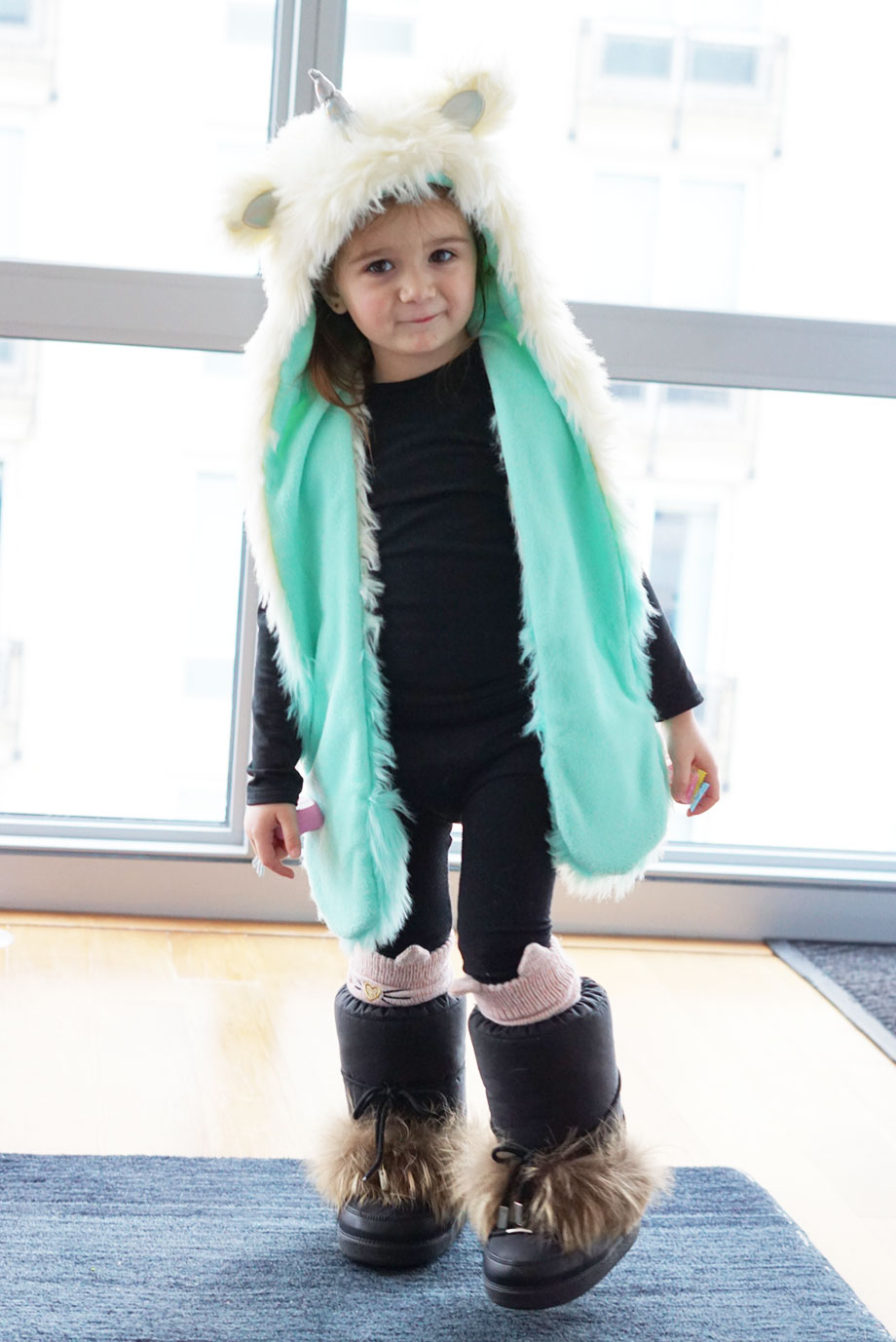 A toddler wears a fur hat with fur boots in Chicago.