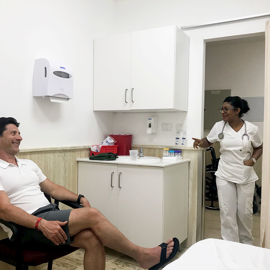 A man sits in a doctor's office with a nurse in Punta Cana.