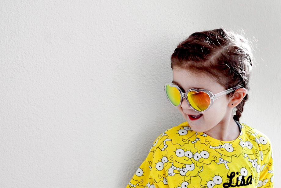 Zelda of Glitter and Bubbles wears her hair in a braid with yellow sunglasses.