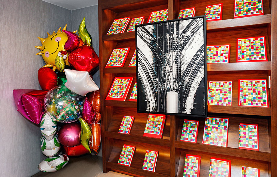A colorful book wall with balloons.
